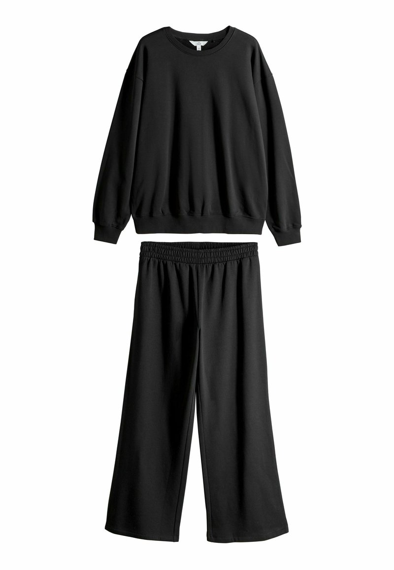 Svarta vida sweatpants med elastisk midja, tillsammans med en matchande långärmad sweatshirt. Båda är gjorda av mjukt mixat bomullstyg.