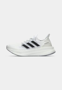 Białe buty sportowe z teksturowaną cholewką z dzianiny, czarno-białym wzorem w trzy paski oraz zaokrągloną podeszwą z brandingiem "Light Boost" i "Ultra Boost".