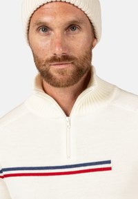 Maglione bianco a maglia con colletto a mezza zip, caratterizzato da strisce orizzontali blu navy e rosse sul petto e una texture a costine.