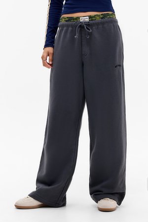 Pantalons de survêtement gris foncé avec une coupe décontractée, une taille élastique, un cordon de serrage ajustable et une doublure intérieure à motifs camouflage.