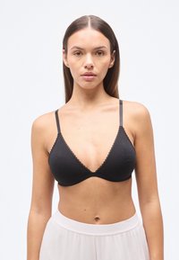 Μαύρο τριγωνικό μπουστάκι από βαμβάκι με ρυθμιζόμενες τιράντες, δαντελωτή διακόσμηση στα κύπελλα και λεία υφή. Χωρίς επένδυση ή μπανέλα.