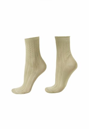 Para beżowych skarpetek do kostek z delikatnym, ażurowym wzorem, prezentowanych na formach w kształcie stóp na białym tle.