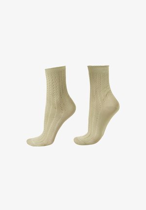 Een paar beige enkellange sokken met een fijn opengebreid patroon, tentoongesteld op voetvormige modellen tegen een witte achtergrond.