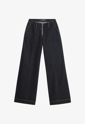 Pantaloni larghi in denim scuro con cuciture a contrasto gialle e chiusura frontale con zip. Due tasche laterali e una vestibilità leggermente strutturata.