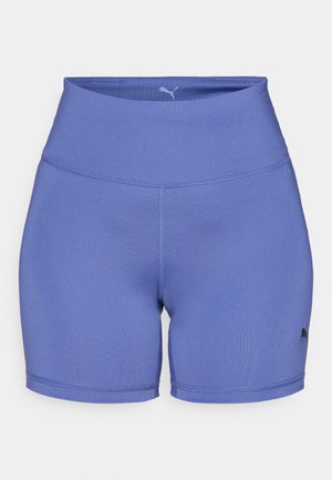 Lilla spordipüksid, mis on valmistatud venivast kangast, kõrge vöökoha ja peente õmblusdetailidega. Logo on trükitud alumisele küljele.