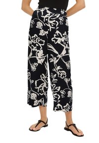 Pantalons larges navy avec motif floral blanc, fabriqués en tissu léger. Présente une taille haute et une longueur cropped.
