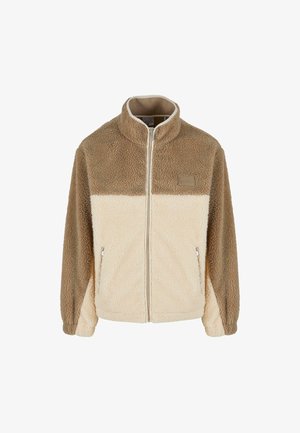 Chaqueta de forro polar con un alto cuello, que presenta un diseño a bloques de color beige y crema, cierre de cremallera y dos bolsillos laterales con cremallera.