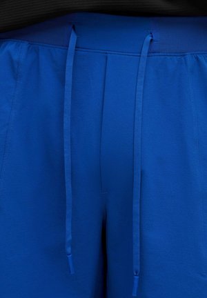 Blue shorts with a textured fabric, elastic waistband, and long drawstrings. No pockets are visible in the image.