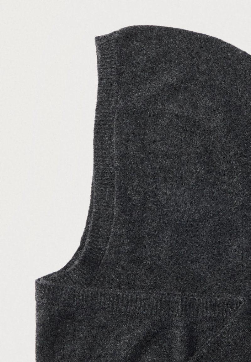 Mørkegrå strikket vest med rund hætte, der har ribbede kanter og en blød tekstur. Materialet virker varmt og behageligt.