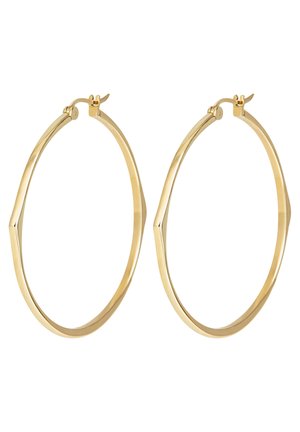 Pár tenkých zlatých kruhových náušnic nepravidelného tvaru s kloubovými zapínáními na bílém pozadí.