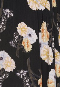 Zwarte stof met een bloemenpatroon, gekenmerkt door grote gele, witte en lichtblauwe bloemen met groene en bruine stelen en bladeren.