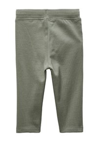 Leggings en coton vert avec une texture lisse, une taille élastique et une coupe droite, présentant des détails de couture minimaux sur les coutures.