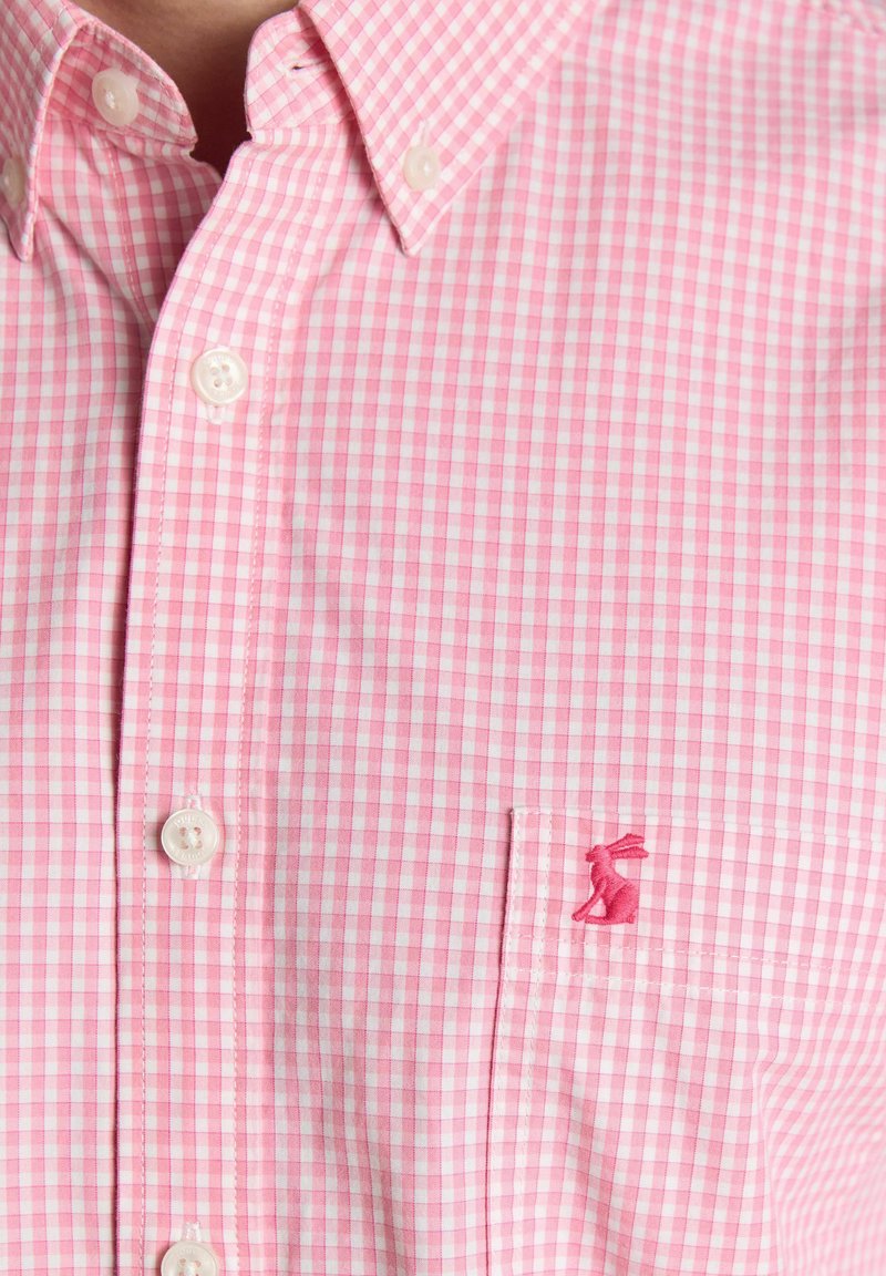 Camicia a quadri rosa e bianca con bottoni e taschino sul petto con un piccolo logo ricamato di un coniglio rosa.