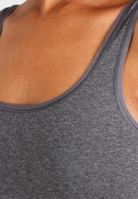 Gray tank top made of soft fabric, featuring a round neckline and gray trim, revealing smooth skin underneath.
