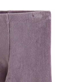 Fioletowe legginsy z korduroju charakteryzują się pionowymi prążkami, grubym pasem i miękką strukturą; zakończone na długości kostek z przeszytymi szwem.
