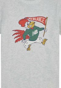 T-shirt grigio chiaro con un fumetto di un gallo con accenti rossi e verdi, che indossa un maglione verde, mentre tiene una bandiera New Balance.
