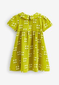 Vestito verde per bambina con maniche corte, colletto alla Peter Pan e stampa floreale di margherite bianche distribuite uniformemente su tutta la stoffa.