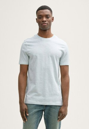 Hellblaues T-Shirt mit kurzen Ärmeln aus weichem Material, mit Rundhalsausschnitt und einer subtilen Textur, kombiniert mit hellblauen Jeans.