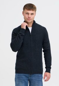 Dunkelgrauer Reißverschluss-Pullover mit langen Ärmeln, gerippten Bündchen und Saum, aus einem weichen Material gefertigt, mit einem Stehkragen.