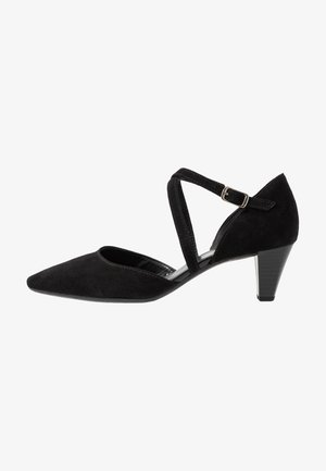 Zwarte suède pump met een spitse neus, kruisschoen en verstelbare gesp. Kenmerkt zich door een 5 cm hoge taps toelopende hak en een zachte binnenvoering.