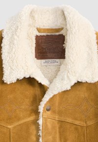 Tan suede jacket with white fleece collar and visible Levi Strauss & Co. leather and fabric labels inside the collar.