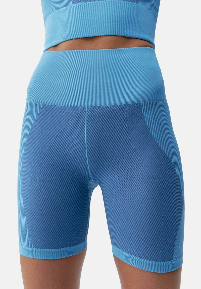 Világoskék sportnadrág, bordázott textúrával, sötétebb kék geometriai mintákkal és vastag derékkal.