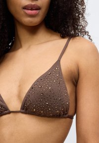 Καφέ τρίγωνο τοπ μπικίνι με στολίδια. Λείο ύφασμα με διάσπαρτες λαμπερές χάντρες. Ρυθμιζόμενοι ιμάντες και λεπτομέρεια με πιέτες στη βάση.
