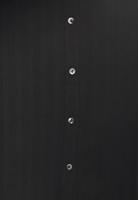 Tissu noir avec une rangée verticale de six petits boutons ronds argentés brillants, espacés uniformément au centre.