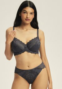 Grauer Spitzen-BH und passende Unterhose mit filigranen Mustern. Der BH verfügt über Bügel, verstellbare Träger und gewellte Kanten für Details.