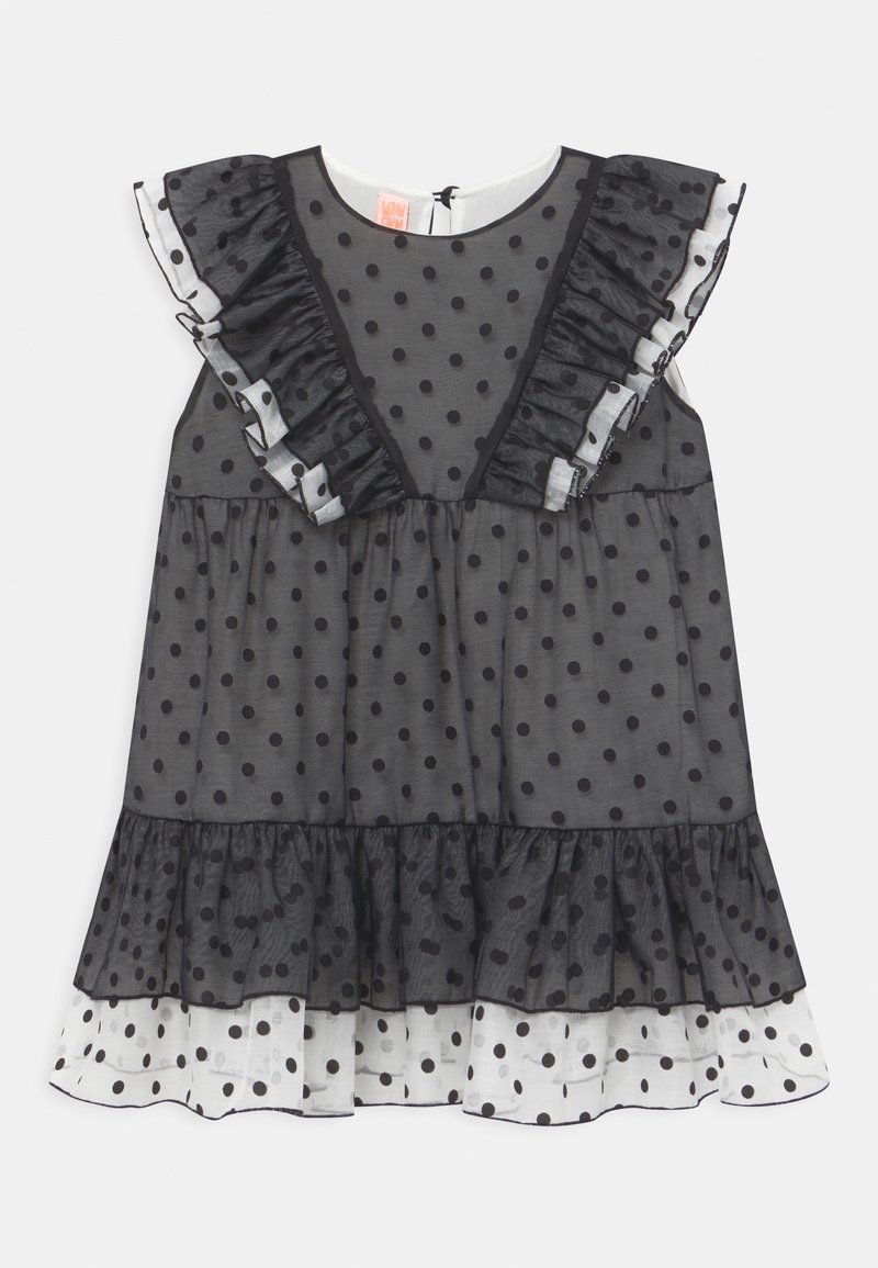 Robe noire à pois avec tissu transparent, manches volantées, décolleté en V et ourlet à niveaux comportant des pois blancs. Fermeture en goutte dans le dos.