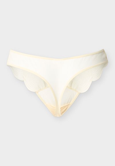 Sous-vêtements pour femmes de couleur crème avec des détails en dentelle festonnée sur les côtés, présentés sur un fond clair uni.