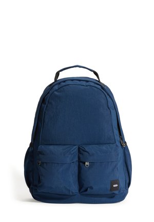Sac à dos bleu foncé avec deux poches zippées à l'avant, une poignée supérieure et un patch logo Vans dans le coin inférieur droit de la poche avant.