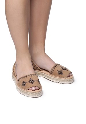 Tan espadrilles with open toes, featuring black stitching and geometric patterns, on a textured jute sole for added grip.