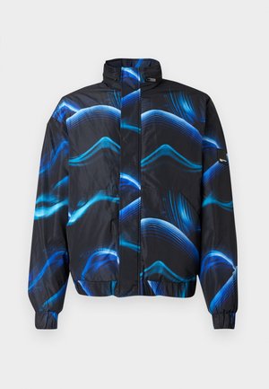 Schwarze und blaue gemusterte Jacke mit hochabschließendem Kragen, Reißverschluss, elastischen Bündchen und wellenförmigen blauen Linien im Material.