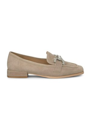 Mocasín de ante beige con tacón plano, que presenta un detalle decorativo de hebilla en tono plateado en la parte frontal y una textura suave.