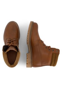 Botas de cuero marrón con cordones, con un acabado suave, suela de goma resistente en tono marrón claro y un detalle de cuello en ante contrastante en el tobillo. Cadenas planas y ojales de metal.