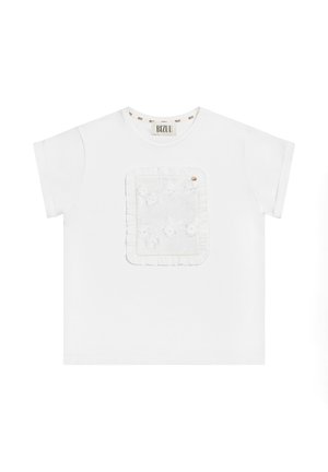 Witte katoenen t-shirt met een textuur, geborduurd patch met ruches rond de randen en een kleine accentknop. Casual korte mouwen.
