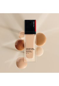 Shiseido SYNCHRO SKIN RADIANT LIFTING FOUNDATION SPF30 - Base de maquillaje - henna