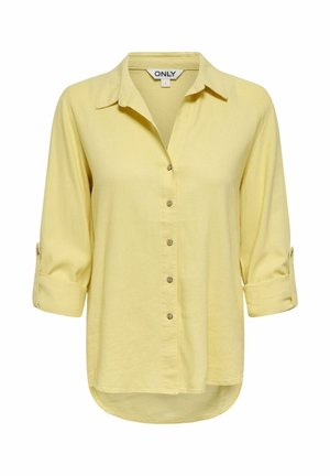 Šviesiai geltona ilgomis rankovėmis marškiniai su sagutėmis, susuktais rankogaliais, aptakiu apykakliu ir šiek tiek išlenktu apatinės dalies kraštu, mažo dydžio, prekės ženklo ONLY.