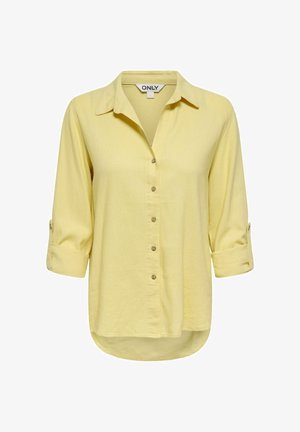 Šviesiai geltona ilgomis rankovėmis marškiniai su sagutėmis, susuktais rankogaliais, aptakiu apykakliu ir šiek tiek išlenktu apatinės dalies kraštu, mažo dydžio, prekės ženklo ONLY.