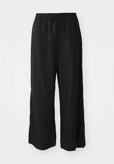 Pantalones de pierna ancha negros hechos de un tejido ligero. Cintura elástica con cordón. Presenta aberturas laterales cerca del dobladillo para facilitar el movimiento.