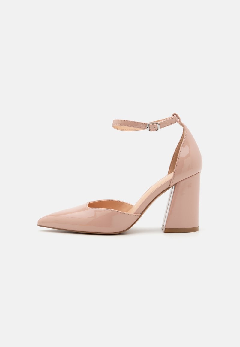 Chaussure à talon haut en cuir verni rose avec bout pointu, bride à la cheville et talon bloc. Texture lisse et design minimaliste.