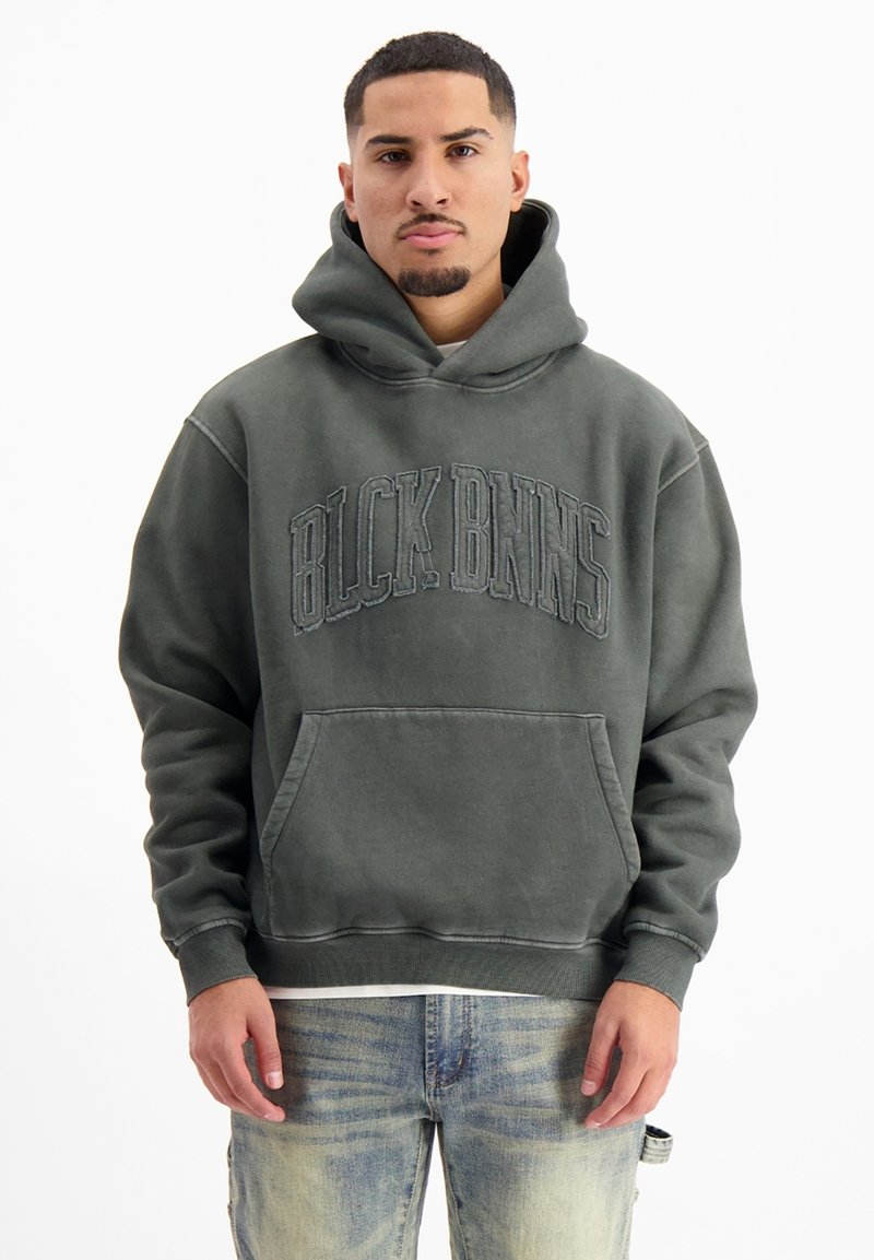 Donkergroene hoodie van zachte stof, oversized pasvorm, met een voorste kangoeroezak. Heeft verhoogde letters "BLCK BNNS" over de borst, ribgebreide manchetten en zoom.