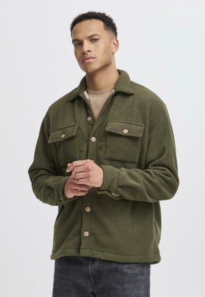 Green fleece shirt jacket with two chest pockets, button closures, and a relaxed fit. Features a collared neck and soft texture.