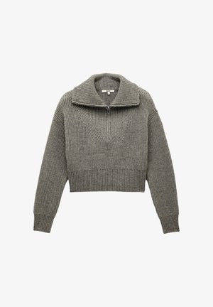 Jersey gris acortado con un gran cuello acanalado, cierre de media cremallera en el frontal y textura de canalé vertical en toda su superficie. Presenta mangas largas y ligeramente ajustadas.