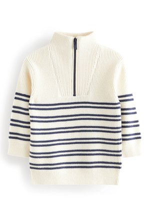Pull côtelé couleur crème avec des rayures horizontales bleu marine, manches longues et une courte fermeture éclair noire sur le col haut.
