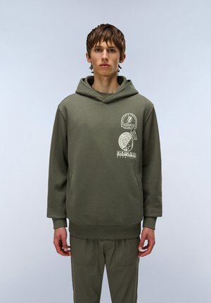 Sweat à capuche vert olive avec une poche kangourou, des poignets et un ourlet côtelés. Présente trois impressions graphiques blanches à l'avant. Tissu doux et texturé.