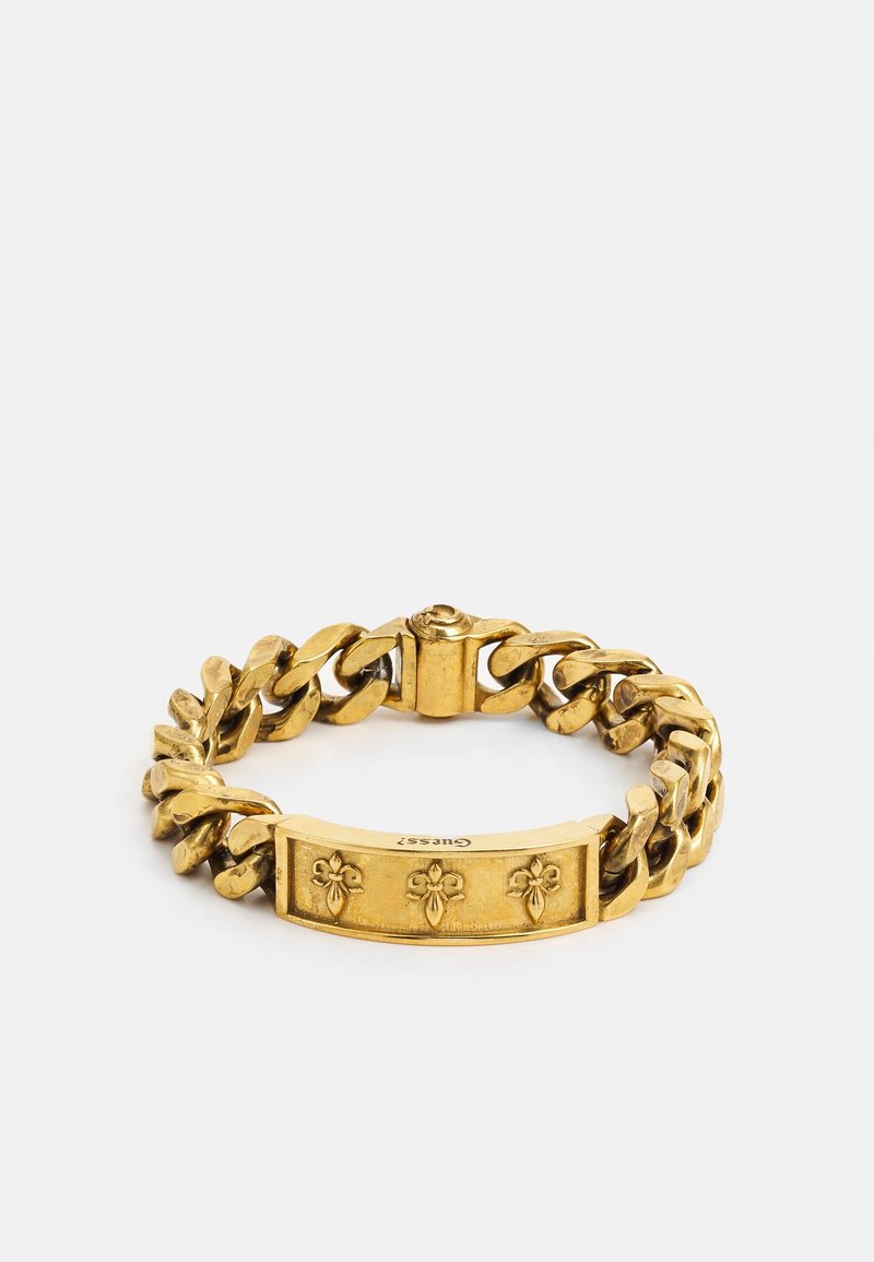 Bracelet à maillons dorés avec plaque gravée ornée de trois symboles de fleur-de-lis et fermoir à clip.
