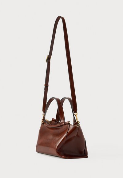 Καφέ δερμάτινη τσάντα με δύο χειρολαβές και αποσπώμενο ιμάντα ώμου. Διαθέτει λεία υφή και δομημένο, στρογγυλεμένο σχήμα.