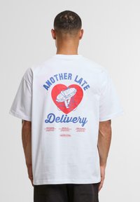White cotton t-shirt featuring a graphic on the back with a red heart, bicycle, and the text "ANOTHER LATE Delivery" in blue.